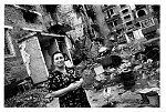 Chechnya, october 2003<br>Grozny, woman and her chicken in front of the house where one appartment is usable, she takes the chicken inside, otherwise it get's stolen.<br><br><br>After the reelection of Kadyrov, for people inside the Chechen republic aswell as in neighboring Ingushetia the situation has not improved, Kadyrov is seen as a Russian marionet who betrayed the Chechens, his army is rudeless and has no interest in protecting the population.<br>In ingushetia the refugees from Chechnya are forced out of their tents,just before winter fall's, back into Chechnya where they claim to have the situation under control.<br><br>Living conditions in and around Chechnya are inhuman after almost a decade of war and destruction.<br>People inside Chechnya are terrorized as well by the Russian occupation as the Kadirov army in a daily and structural way and the disappearance and execution of people are more rules than exception.<br>The Chechen fighters are divided and not able to finance the war, if they have the money they buy their weapons from the Russian enemy who are underpaid for their services.<br><br>For the Chechens who fled their country during the war the situation is almost as bad, mostly ending up in neighboring Ingushetia, living in camps with little or no facilities in tents who fall apart after the strong winters and even in stables normally used for animals.<br>Since also drug smugglers and criminals fled Chechnya, an increasing number of the refugees become drug addicted.<br><br>Most  NGO's working in Ingushetia can not enter Chechnya to do their important work as the risk of being kidnapped is too high and Russian government is not supporting in any way.<br><br>