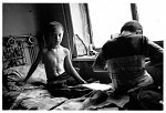 Chechnya, october 2003<br>Beslan plays with his toycar, while his brother studies while the last light falls through the plastic shields, they have no light after dark.<br>During the 2000 war Beslan was hit by a granade scrapple in his stomag, he was lucky to survive.<br><br><br>After the reelection of Kadyrov, for people inside the Chechen republic aswell as in neighboring Ingushetia the situation has not improved, Kadyrov is seen as a Russian marionet who betrayed the Chechens, his army is rudeless and has no interest in protecting the population.<br>In ingushetia the refugees from Chechnya are forced out of their tents,just before winter fall's, back into Chechnya where they claim to have the situation under control.<br><br>Living conditions in and around Chechnya are inhuman after almost a decade of war and destruction.<br>People inside Chechnya are terrorized as well by the Russian occupation as the Kadirov army in a daily and structural way and the disappearance and execution of people are more rules than exception.<br>The Chechen fighters are divided and not able to finance the war, if they have the money they buy their weapons from the Russian enemy who are underpaid for their services.<br><br>For the Chechens who fled their country during the war the situation is almost as bad, mostly ending up in neighboring Ingushetia, living in camps with little or no facilities in tents who fall apart after the strong winters and even in stables normally used for animals.<br>Since also drug smugglers and criminals fled Chechnya, an increasing number of the refugees become drug addicted.<br><br>Most  NGO's working in Ingushetia can not enter Chechnya to do their important work as the risk of being kidnapped is too high and Russian government is not supporting in any way.<br><br>