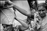 India, Tamil Nadu,march2005.<br>Foodsupply, a minimum of rice is given to a family.<br><br>Victims of the Tsunami are struggling to survive after the Tsunami, their main business as fisherman have been made impossible by destroyed boats and nets.<br>while improvising and take the risk to fish the sea using a inferior boat, local people don't want to eat the fish, so prizes go down to 20% of before.<br><br>The Indian Government claims to have the situation under control and don't accept foreign aid, in the meantime they move fisherman away from the beaches to remote areas, where their chances of survival will be even less.<br>